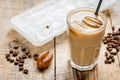 Coffee ice cubes and beans with latte on wooden desk background Royalty Free Stock Photo