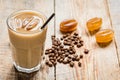 Coffee ice cubes and beans with latte on wooden desk background Royalty Free Stock Photo