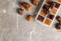 Coffee ice cubes and tray on grey table, flat lay. Royalty Free Stock Photo