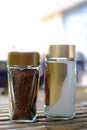 Coffee jars are paired with sugar jars on a bamboo table. Soft background, natural light.