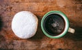 Coffee and krapfen with powder sugar, two, top view and isolated, wooden background.