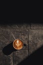 Coffee latte art in black cup on the concrete floor Royalty Free Stock Photo