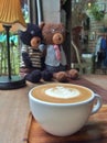 Coffee with latte art and two bear dolls Royalty Free Stock Photo