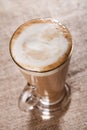 Coffee latte with closeup froth on rustic