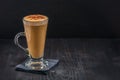 Coffee latte in glass with froth of milk on black paper napkin o Royalty Free Stock Photo