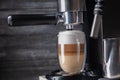 Coffee latte macchiato is poured into a glass cup in a coffee machine Royalty Free Stock Photo