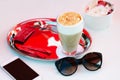 Coffee latte, smartphone, sun glasses and yogurt at table in caf Royalty Free Stock Photo