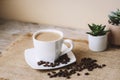 Coffee latte in white cup, coffee beans on sackcloth napkin. Closeup Royalty Free Stock Photo