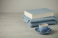 Coffee in a light blue cup and book in blue binding with a knitted scarf on a wooden background. Royalty Free Stock Photo