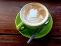 Coffee in lime green cup and saucer. Art Latte.