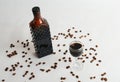 Coffee liqueur in dark glass bottle and poured into a glass. White background, scattered coffee beans Royalty Free Stock Photo
