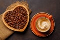 Coffee love: A cup and heart-shaped bowl with roasted beans Royalty Free Stock Photo