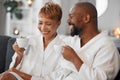 Coffee, love and mature couple on a sofa, happy and laughing while drinking coffee and relax in bathrobe in living room Royalty Free Stock Photo