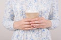 Coffee lover concept. Cropped close up photo of hands holding brown paper cup  grey background Royalty Free Stock Photo