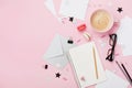 Coffee, macaron, office supply and clean notebook on pink pastel table top view for blogging. Flat lay style. Beautiful breakfast.