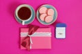 Coffee with macarons and ring on a pink background. An offer of marriage. Top view, toned image Royalty Free Stock Photo