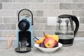 Coffee machine and electric kettle in the kitchen. Fresh fruits in white plate. Royalty Free Stock Photo