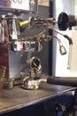 Part of the espresso machine, you can see the group head of the coffee machine. The portafilter is above the drip tray and below