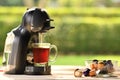 Coffee machine making coffee with capsules on wooden table