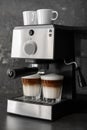 Coffee machine making latte on dark table Royalty Free Stock Photo