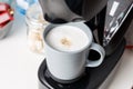 The coffee machine pours cappuccino into the cup. Coffee-make, coffee from the machine at home Royalty Free Stock Photo