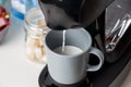 The coffee machine pours cappuccino into the cup. Coffee-make, coffee from the machine at home Royalty Free Stock Photo