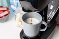 The coffee machine pours cappuccino into the cup. Coffee-make, coffee from the machine at home Royalty Free Stock Photo