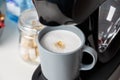 The coffee machine pours cappuccino into the cup. Coffee-make, coffee from the machine at home Royalty Free Stock Photo