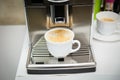 The coffee machine pours freshly brewed coffee into a white Cup. Coffee with foam Royalty Free Stock Photo