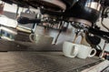 Coffee machine serving two white cups with reflections, steam and water drops Royalty Free Stock Photo