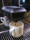 Close-up of espresso pouring from coffee machine to make latte Royalty Free Stock Photo