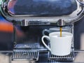 Close-up of espresso pouring from coffee machine to make latte Royalty Free Stock Photo