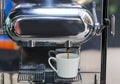 Close-up of espresso pouring from coffee machine to make latte Royalty Free Stock Photo