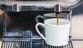 Close-up of espresso pouring from coffee machine to make latte Royalty Free Stock Photo