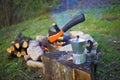 A coffee maker and an axe near a fire. Royalty Free Stock Photo