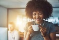 Coffee makes me happy. a young businesswoman enjoying a cup of coffee while standing in the office. Royalty Free Stock Photo