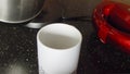 Coffee making in white cup on black table. Add two sugar cubes, one teaspoon of instant coffee and pouring a hot water from a kett