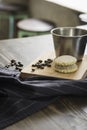 Coffee metal cup and roasted coffee beans with a small cheese cake on vintage and rustic kitchen board in a small restaurant in Royalty Free Stock Photo