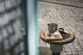 Coffee metal cup and roasted coffee beans with a small cheese cake on vintage and rustic kitchen board in a small restaurant in Royalty Free Stock Photo