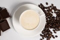 Coffee with milk cream, cappuccino in a saucer cup and chocolate on a white background Royalty Free Stock Photo