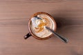 Coffee with milk in a fired earthenware mug with a small spoon. Royalty Free Stock Photo