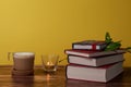 Coffee with milk and books on a brown wooden table.