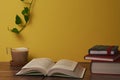 Coffee with milk and books on a brown wooden table.