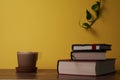 Coffee with milk and books on a brown wooden table.