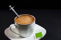 Coffee with milk on a plate with a syringe inside the coffee Royalty Free Stock Photo