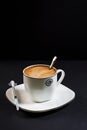 Coffee with milk in a porcelain cup with a syringe on plate Royalty Free Stock Photo