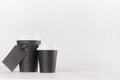 Coffee mockup - different size black paper cups with white cap and blank label on white wood table with copy space, coffee shop.