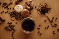 Coffee moody flat lay. Glass cup with fresh coffee and roasted beans,ground coffee on spoon, macarons, chocolate, cinnamon on