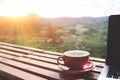 Coffee morning and laptop on wooden table with beautiful mountain background. Worklife balance concept