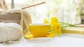 Coffee morning.  Yellow steaming cup of hot coffee for relax after working hobbies crochet on white wooden near window with flower Royalty Free Stock Photo